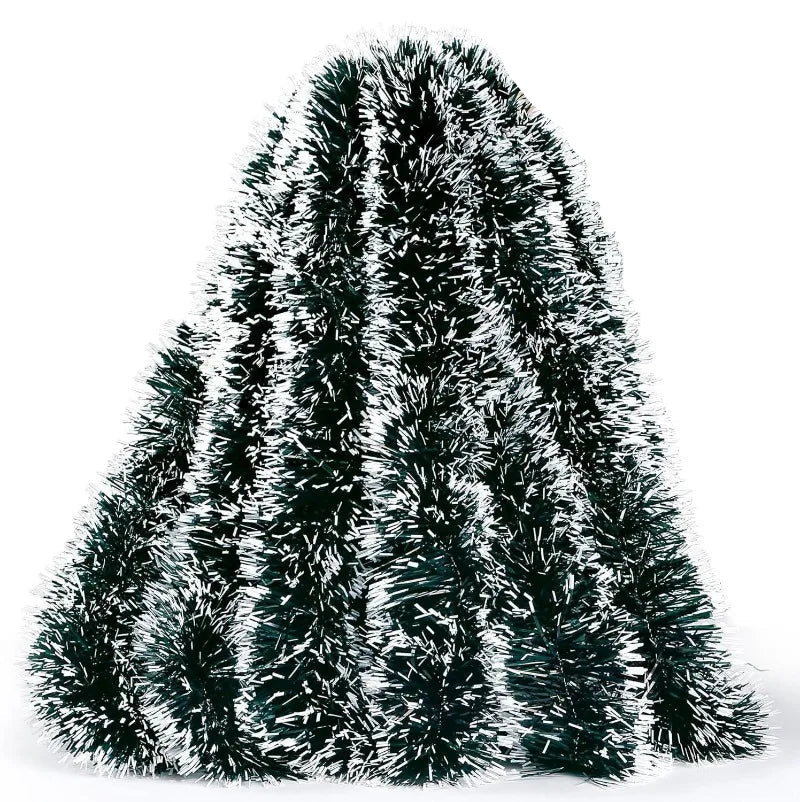 Decorative tinsel tree with a hand holding it on a white background